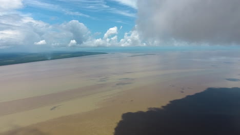 Wunderschöne-Luftlandschaft-Mit-Drohnenansicht-Der-Mündung-Des-Mana-Flusses-Entlang-Der-Wolken.-Guayana